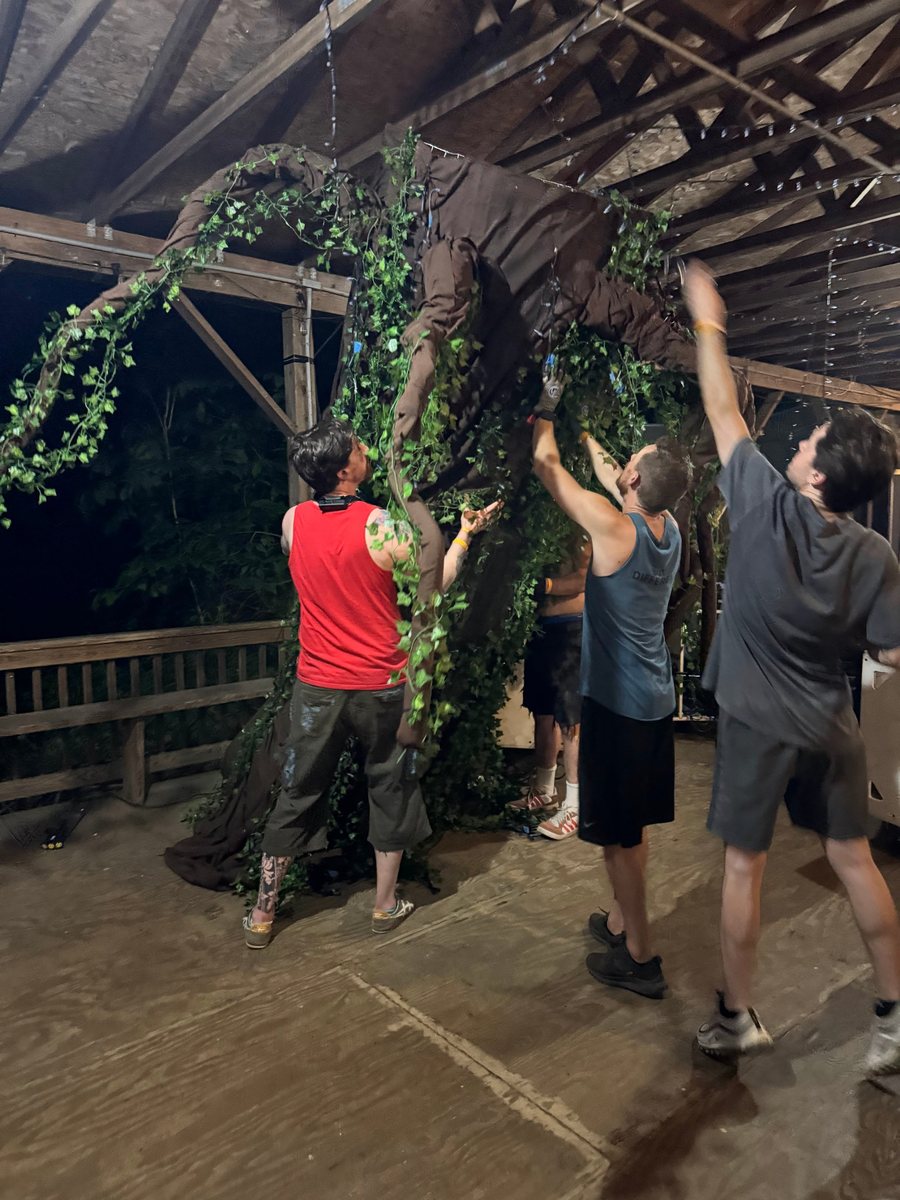The crew raising the Tree of Souls inside the Pavilion, its ivy-wrapped branches reaching across the rafters
